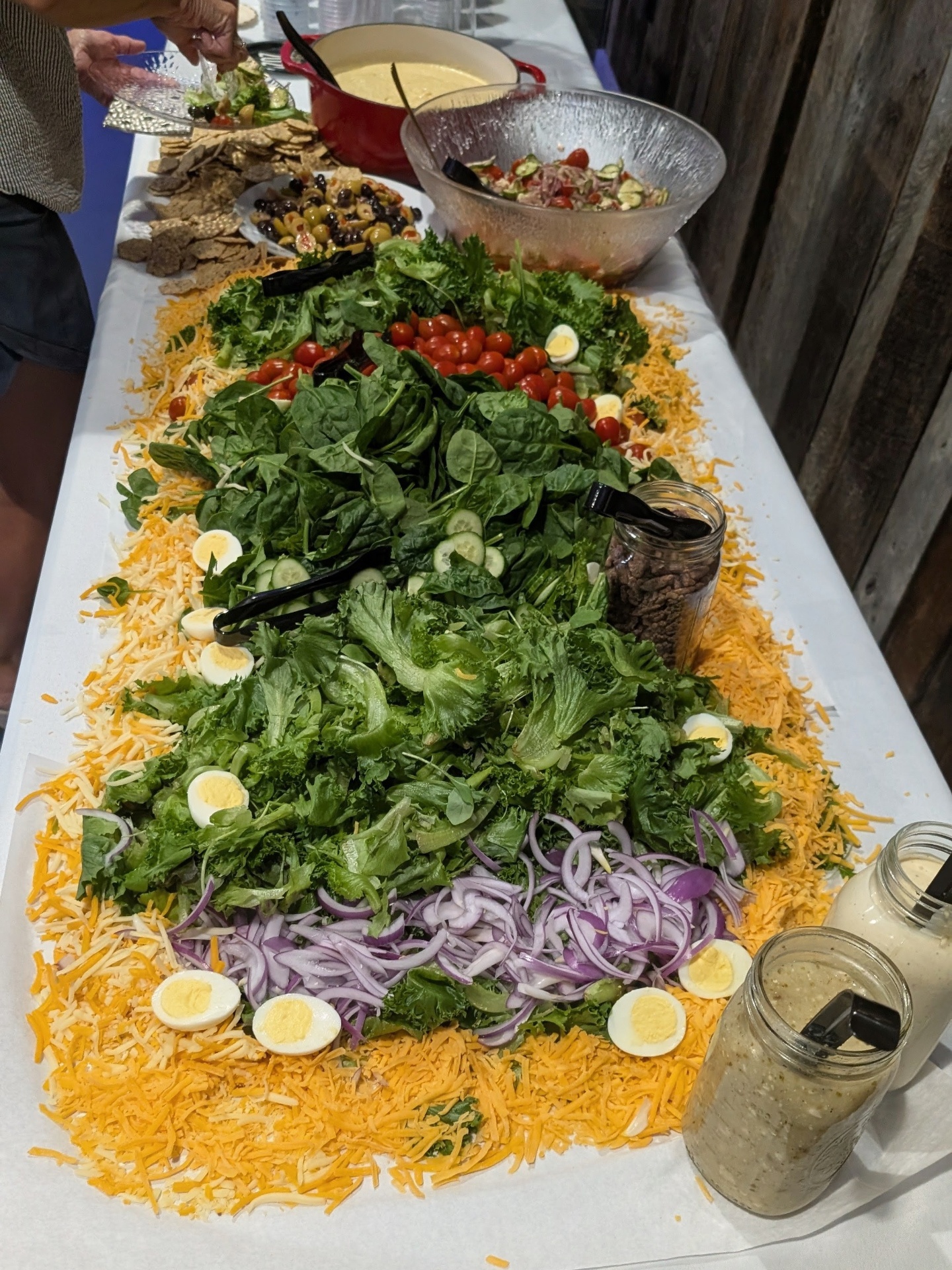 Six-foot chopped salad with spinach, romaine, cherry tomatoes, cucumbers, quail eggs, shredded cheddar, red onion, and house-made dressings